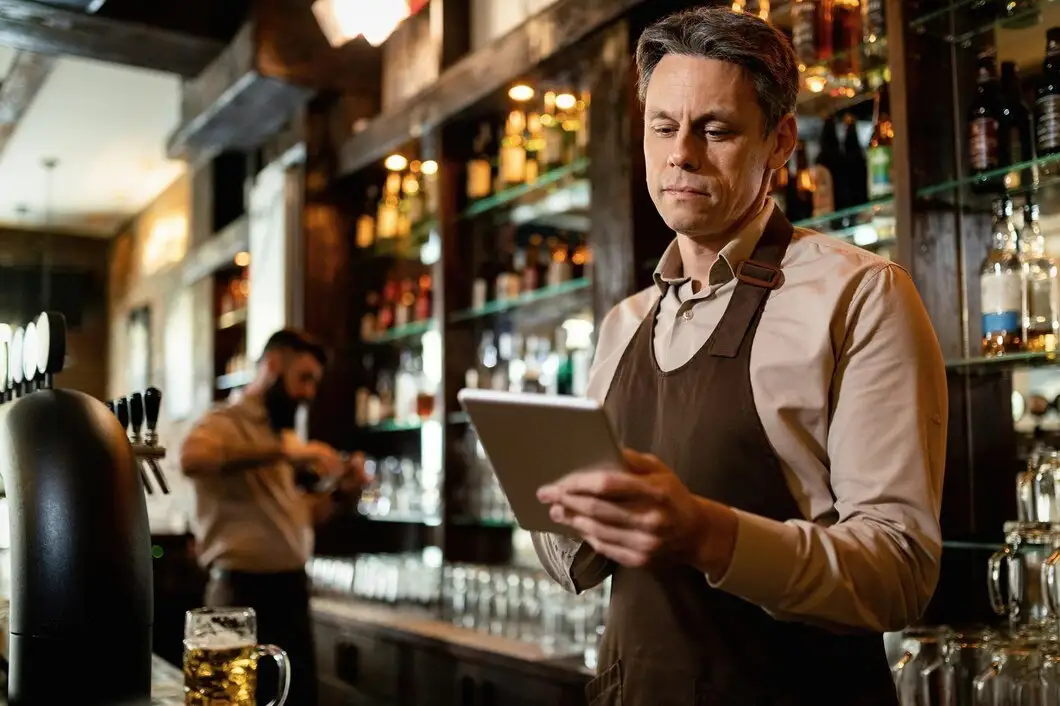 Camarero de hotel tomando nota con una tablet