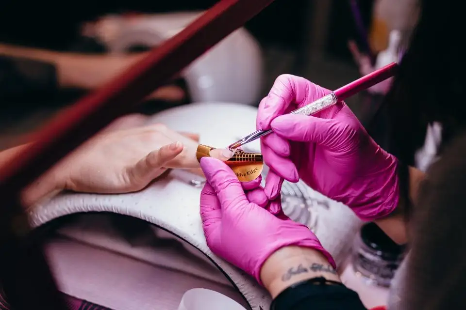 Manicura aplicant esmalt a les ungles d’una clienta