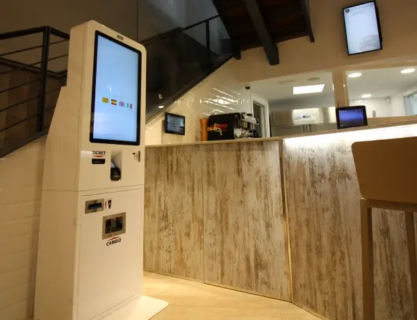 Quiosc T-Quiosk amb mòdul d’efectiu instal·lat al costat del taulell d’un local de restauració