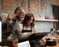 Equipo de trabajo utilizando un dispositivo TPV en una pasteleria